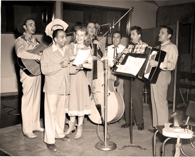 "Carolina Cotton Calls" was a popular radio show for the AFRS. It ran from 1952-53. The first episodes included a fine band headed by Charley Aldridge, far left. Standing between him and Carolina is producer Frank Seely.